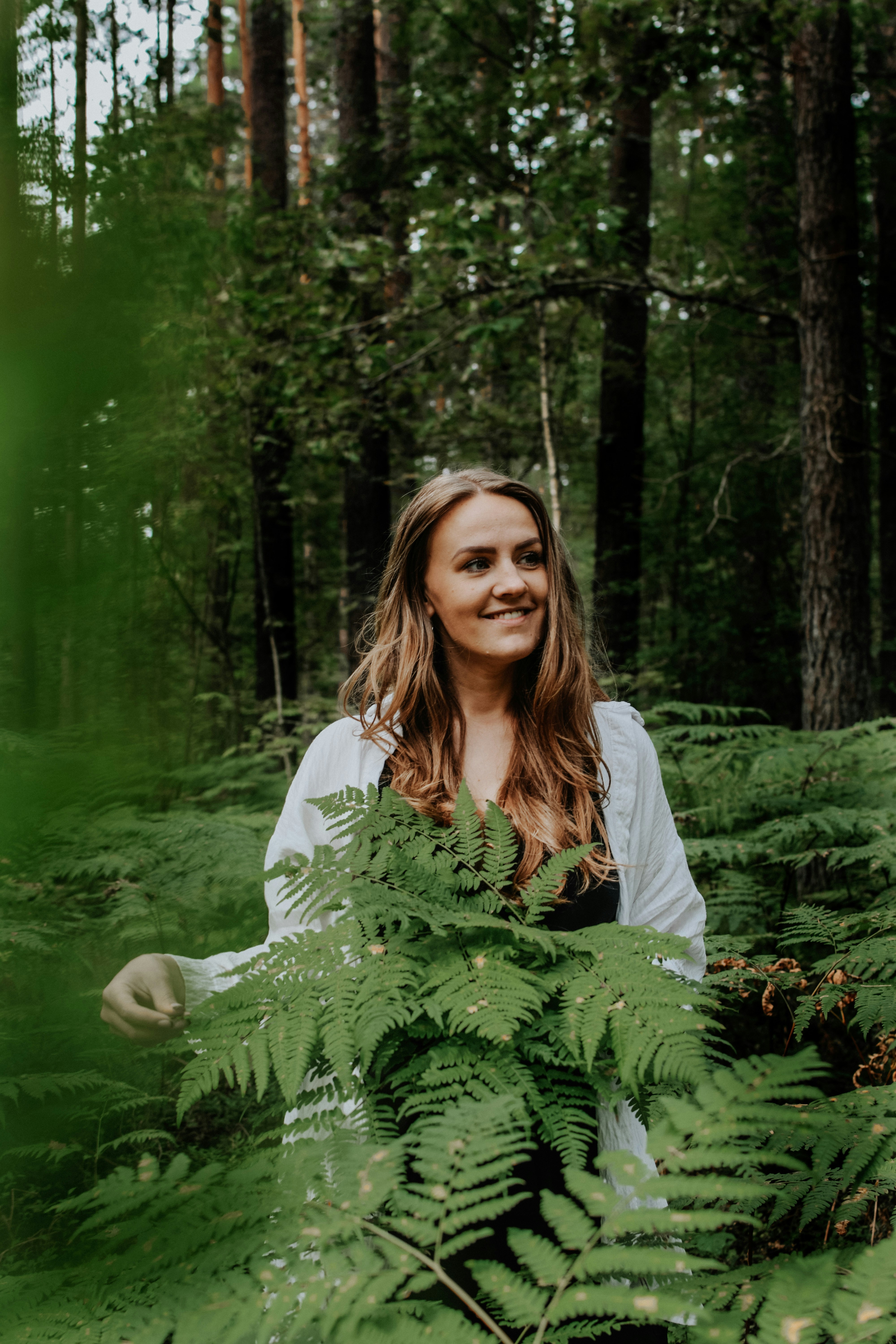 A woman standing in the middle of a forest photo – Free Forest Image on ...