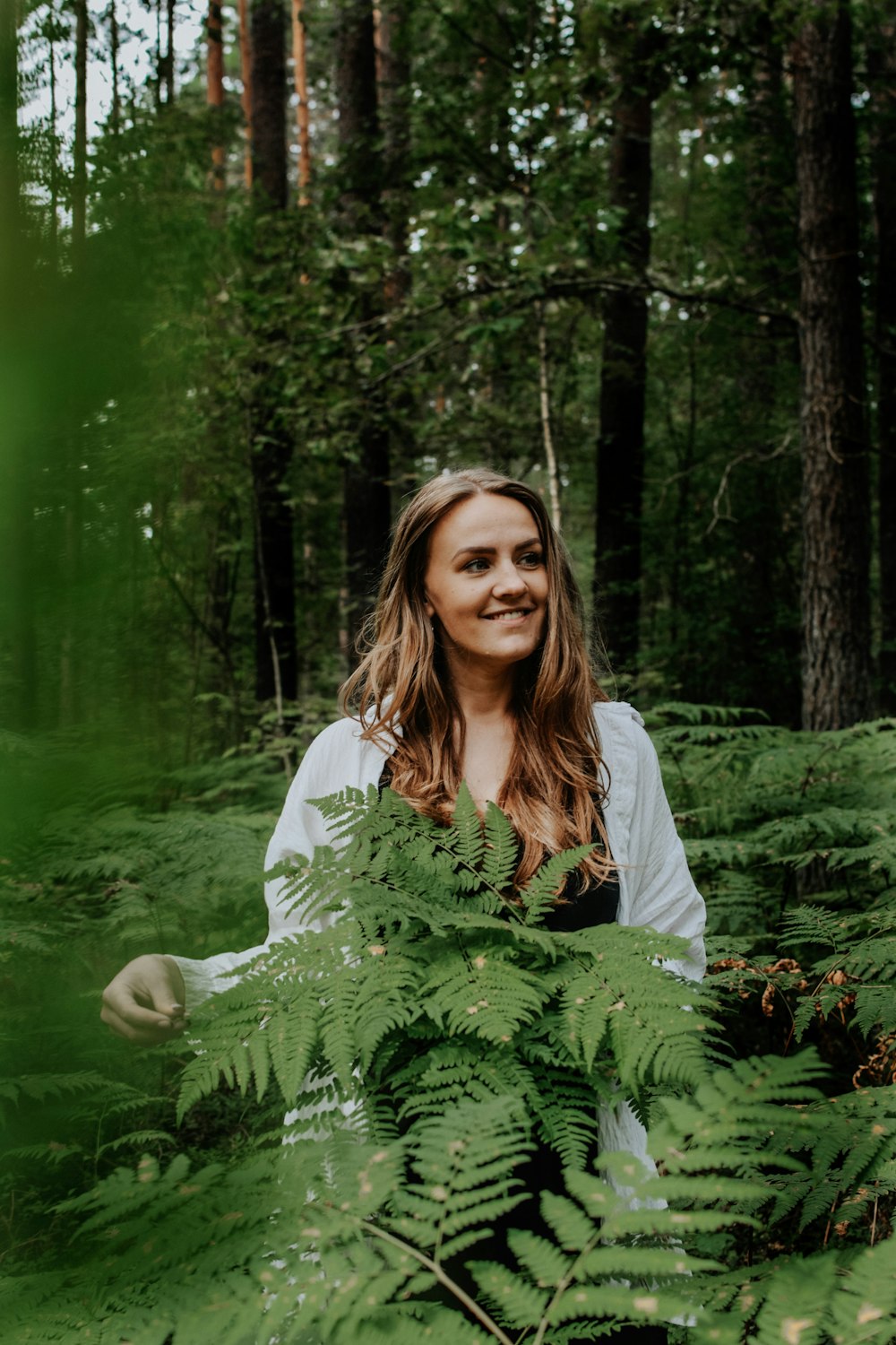 a woman standing in the middle of a forest