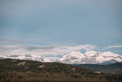 A panoramic view of majestic mountains under a clear blue sky.