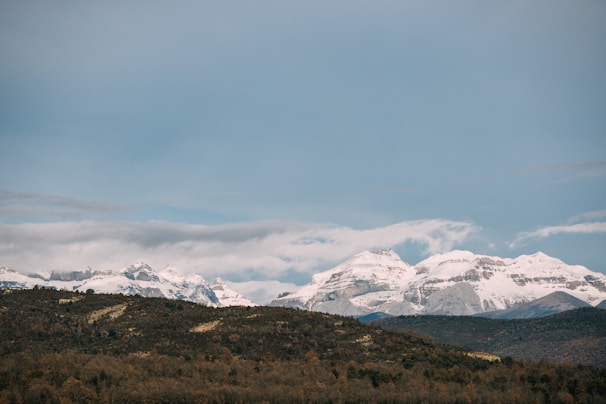 A panoramic view of majestic mountains under a clear blue sky.