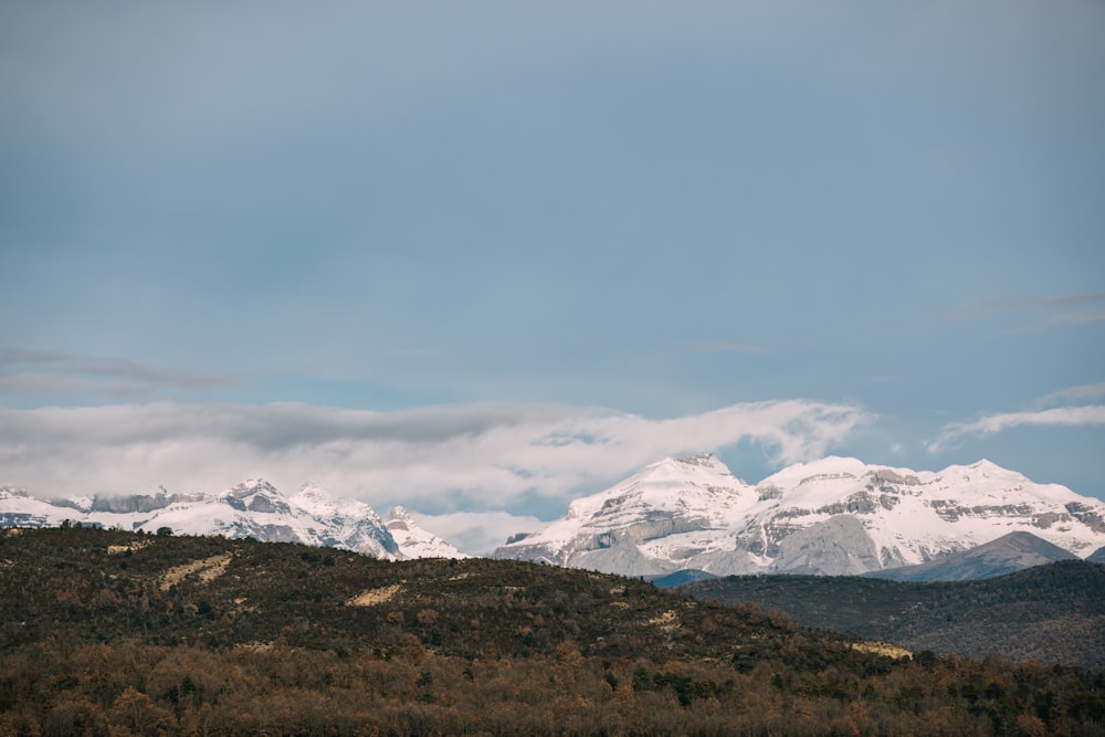 a mountain range with snow covered mountains in the distance