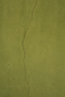 a green wall with a crack in it
