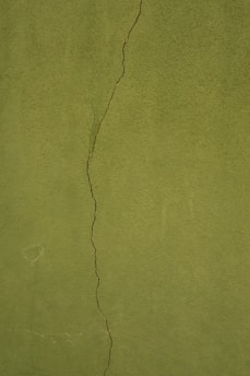 a green wall with a crack in it