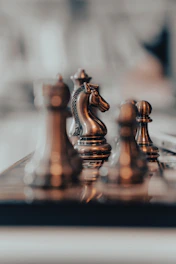 Close-up of a chess knight piece on a gray chessboard, representing strategic business moves.