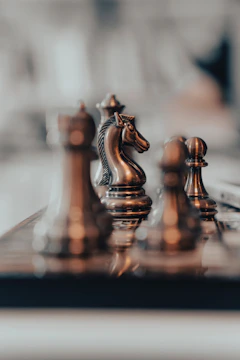 Close-up of a chess knight piece on a gray chessboard, representing strategic business moves.