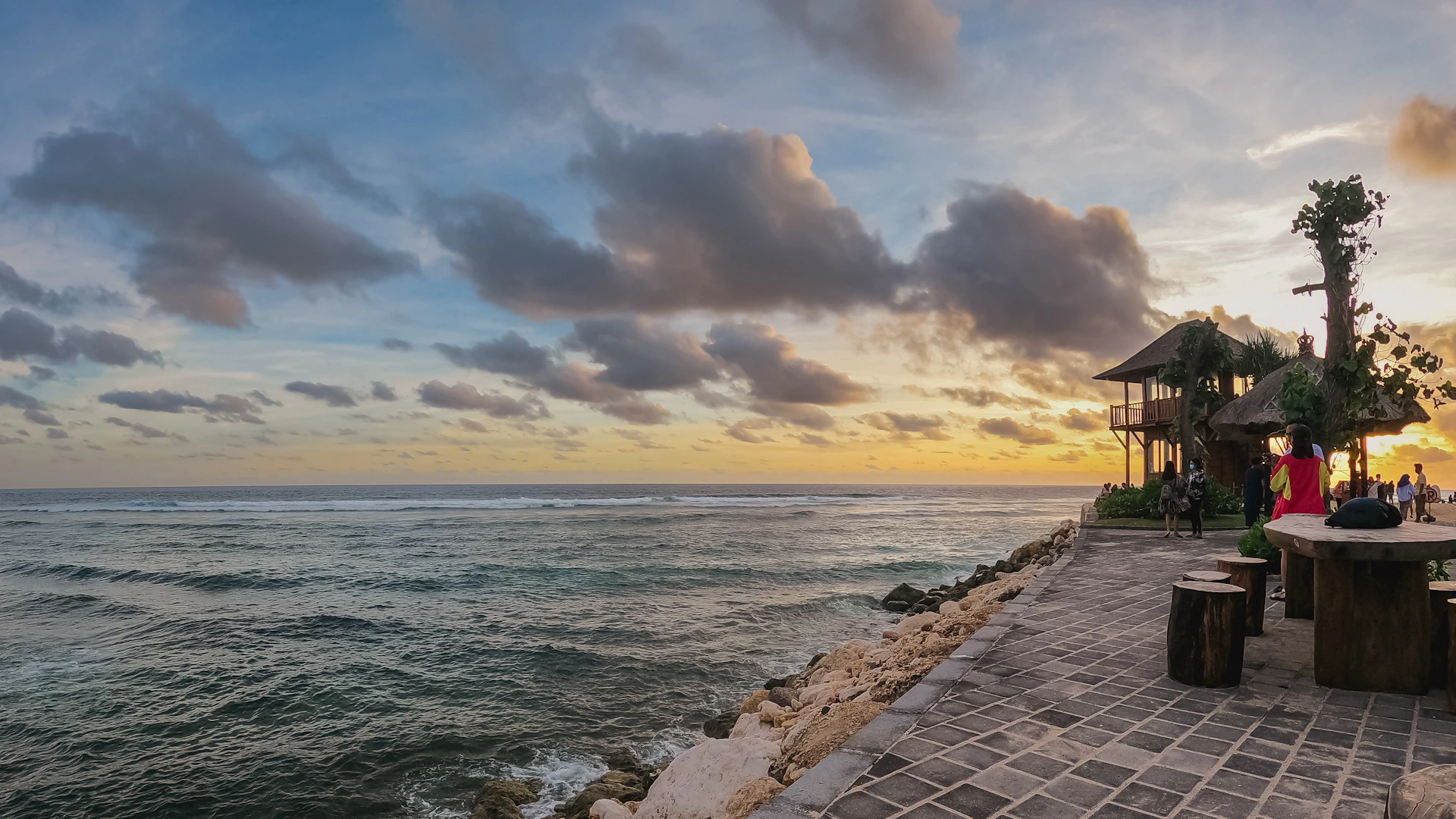 a couple of benches sitting on top of a pier next to the ocean