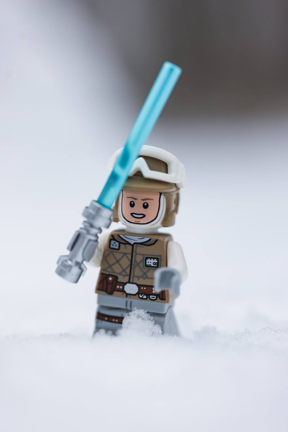 a lego star wars character holding a blue light saber
