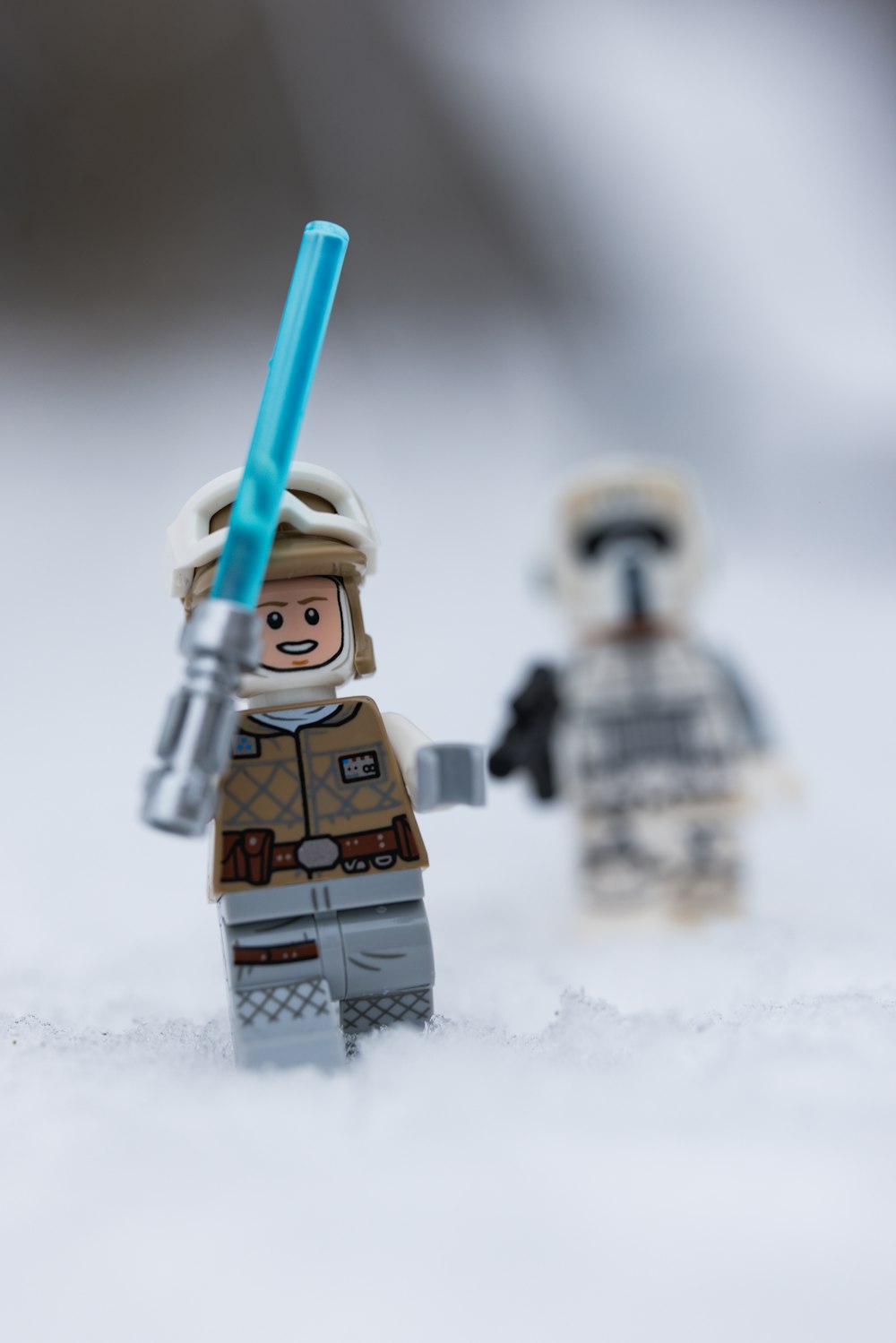 a lego star wars character holding a blue light saber