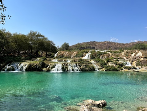 a body of water with a waterfall in the background