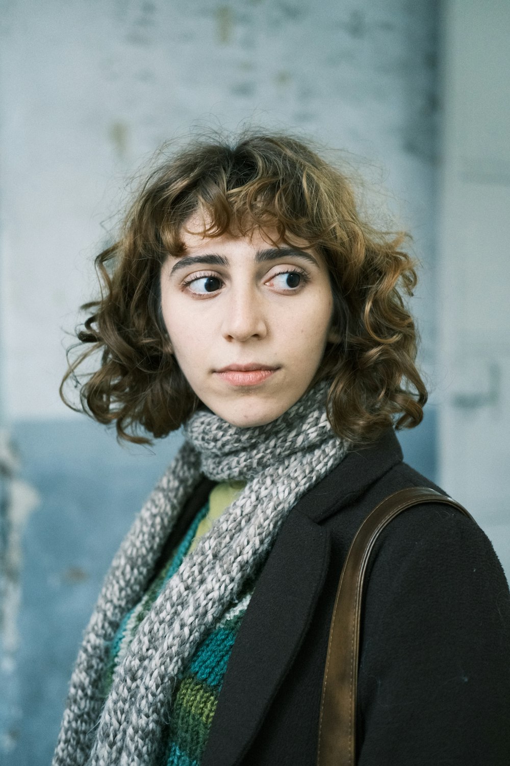 a woman with curly hair wearing a scarf