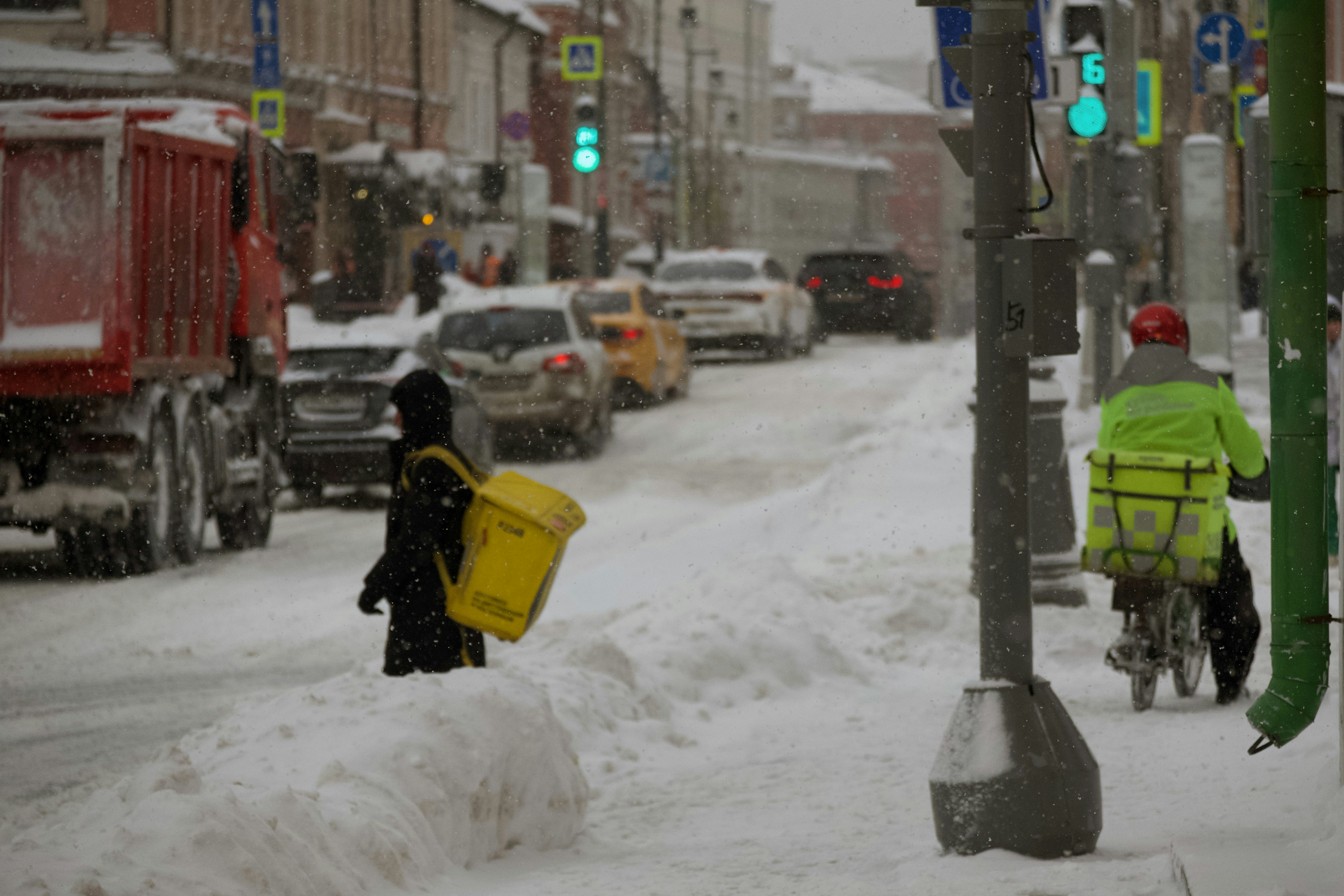 a person riding a bike down a snow covered street