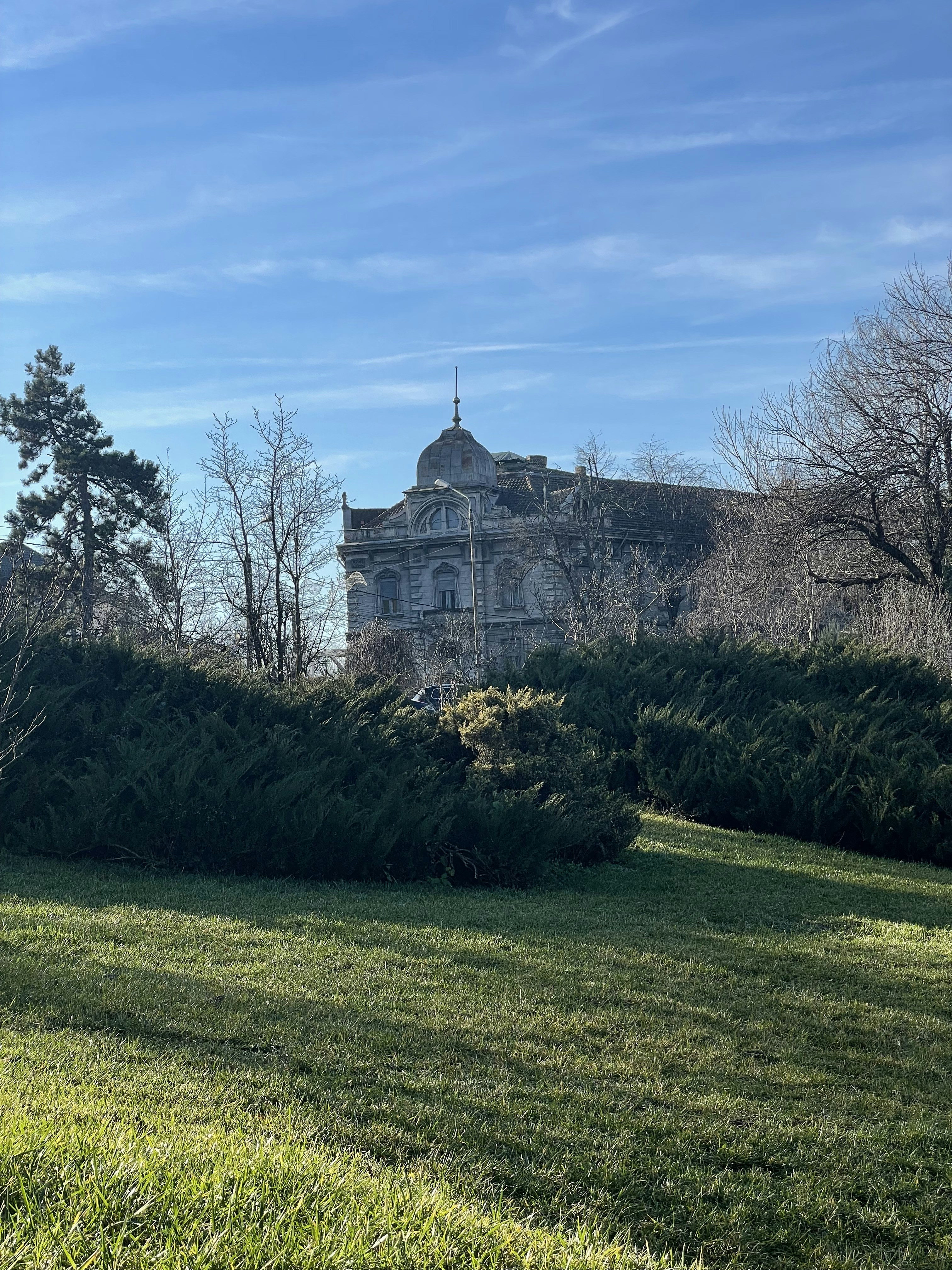 Un gran edificio sentado en la cima de un exuberante campo verde