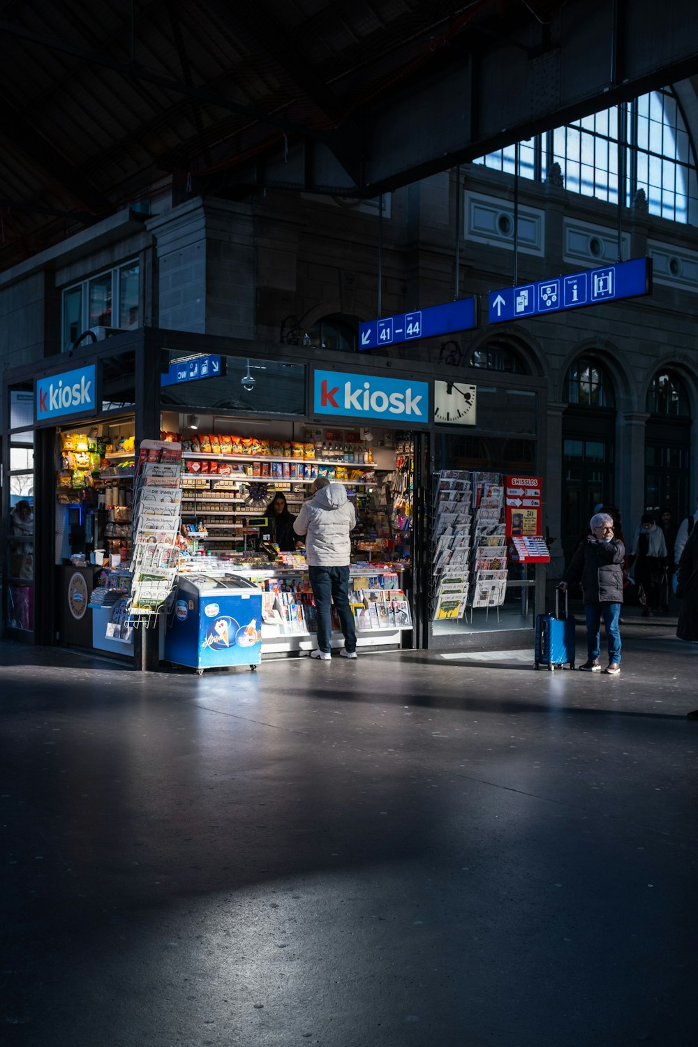 un groupe de personnes debout à l’extérieur d’un kiosque