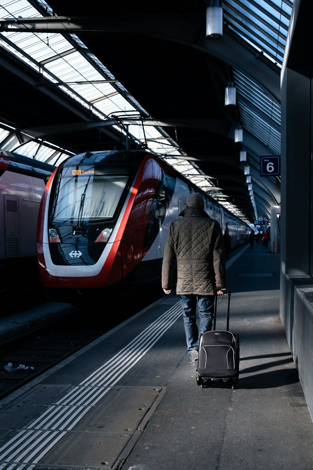 a man with a suitcase walking towards a train