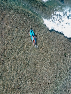 a person laying on a surfboard in the water