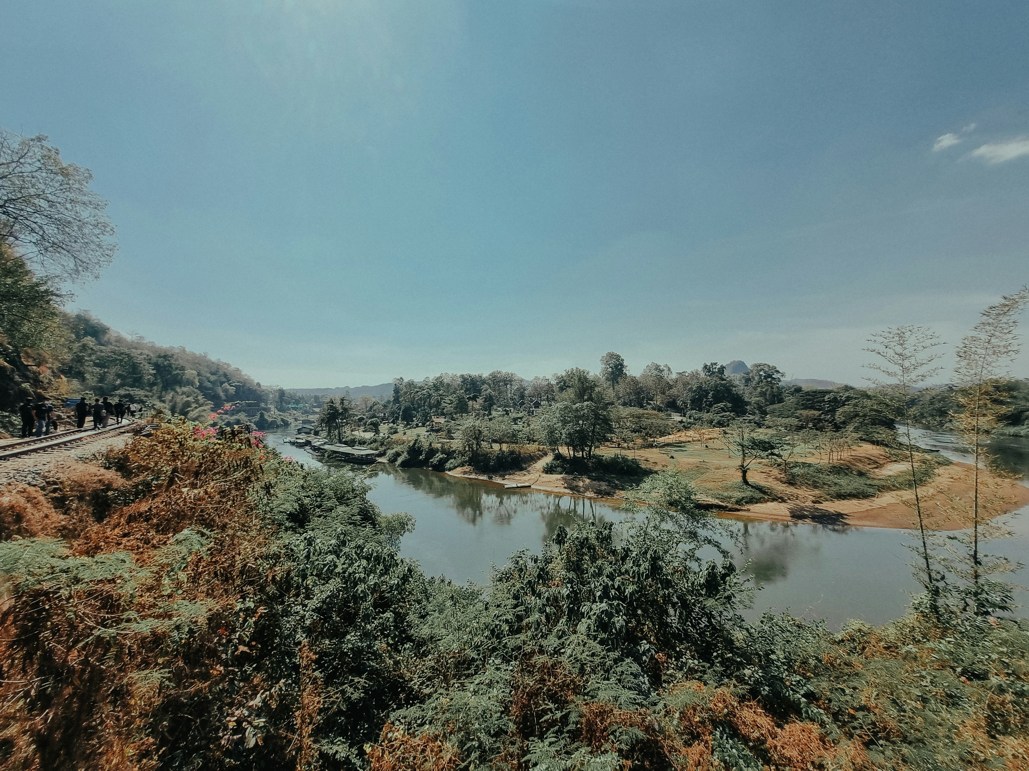 a view of a river and a train on the tracks