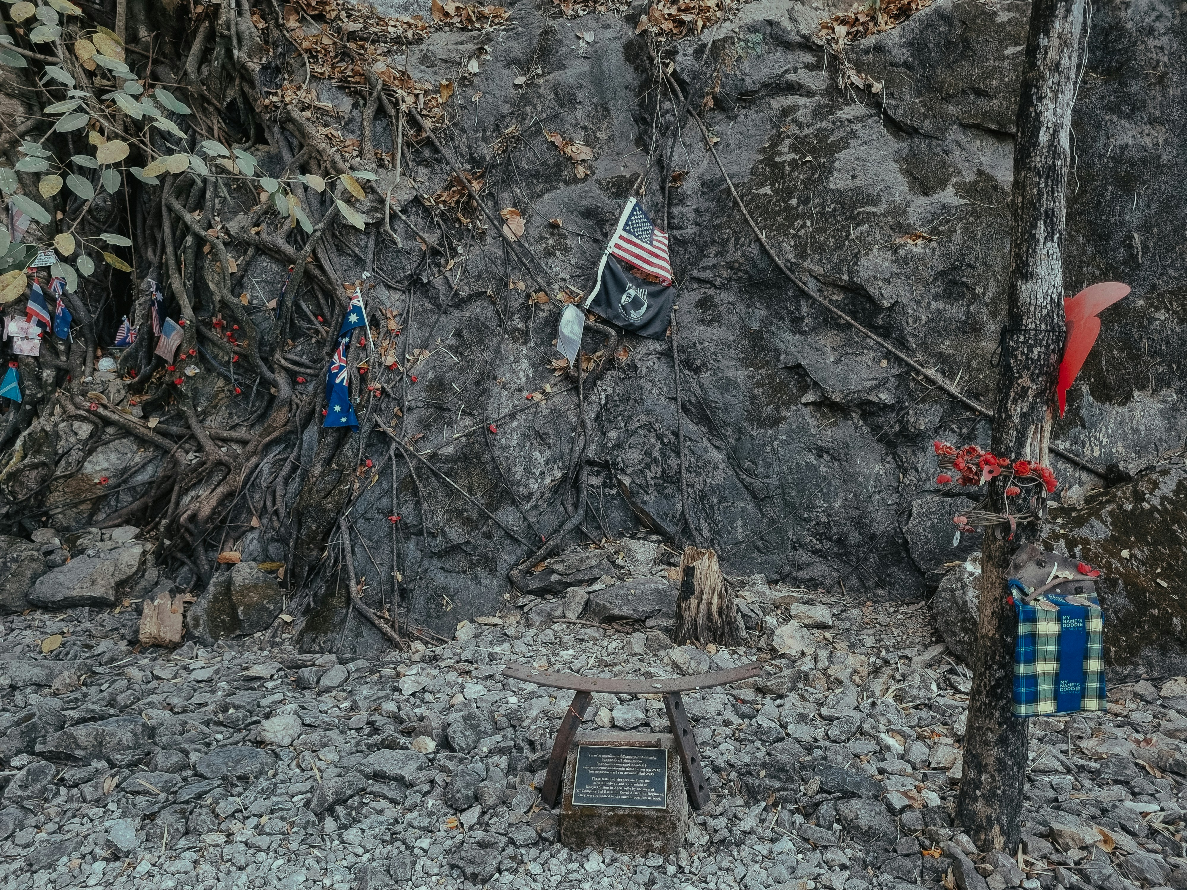 a stone wall with a plaque and flags on it