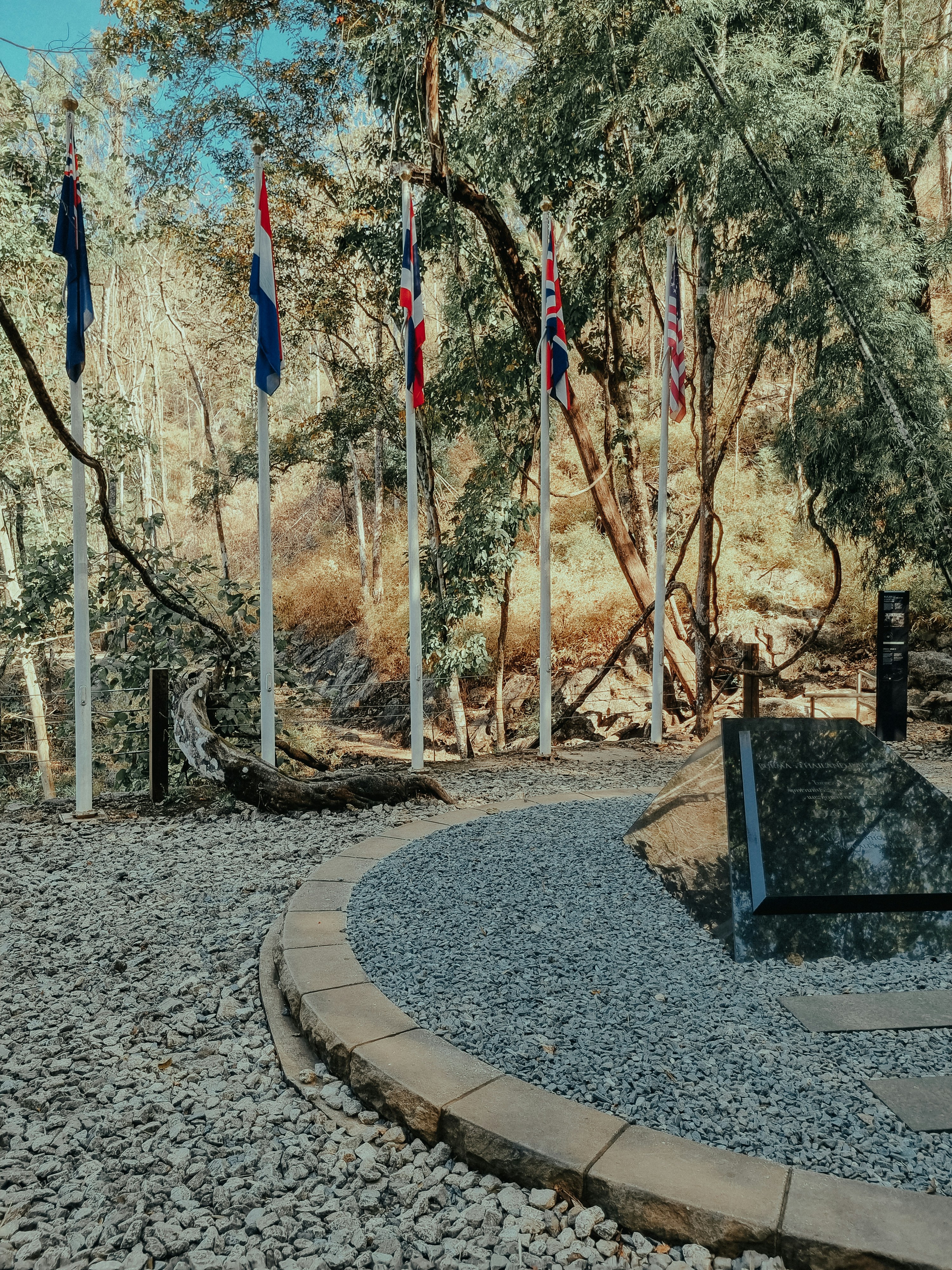 a park with flags and a bench in the middle of it