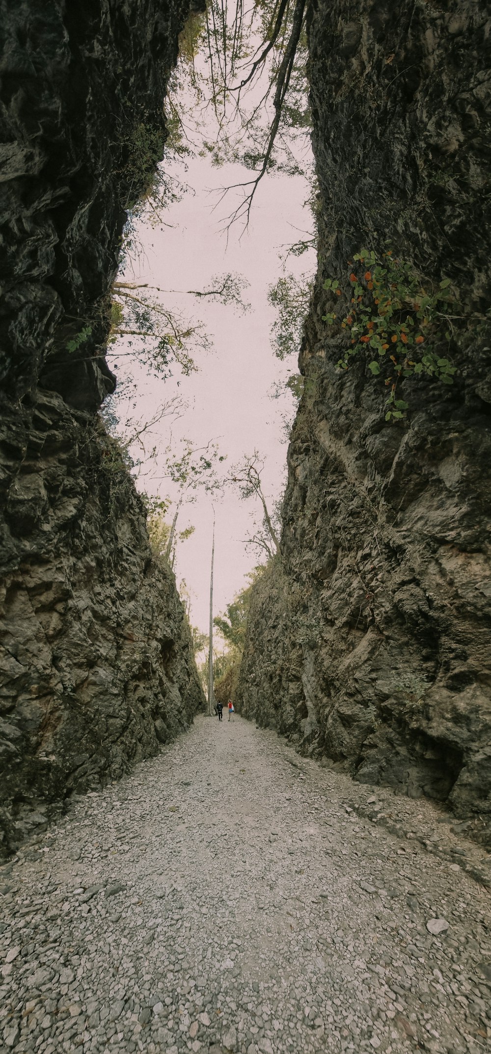 a person walking down a path between two large rocks