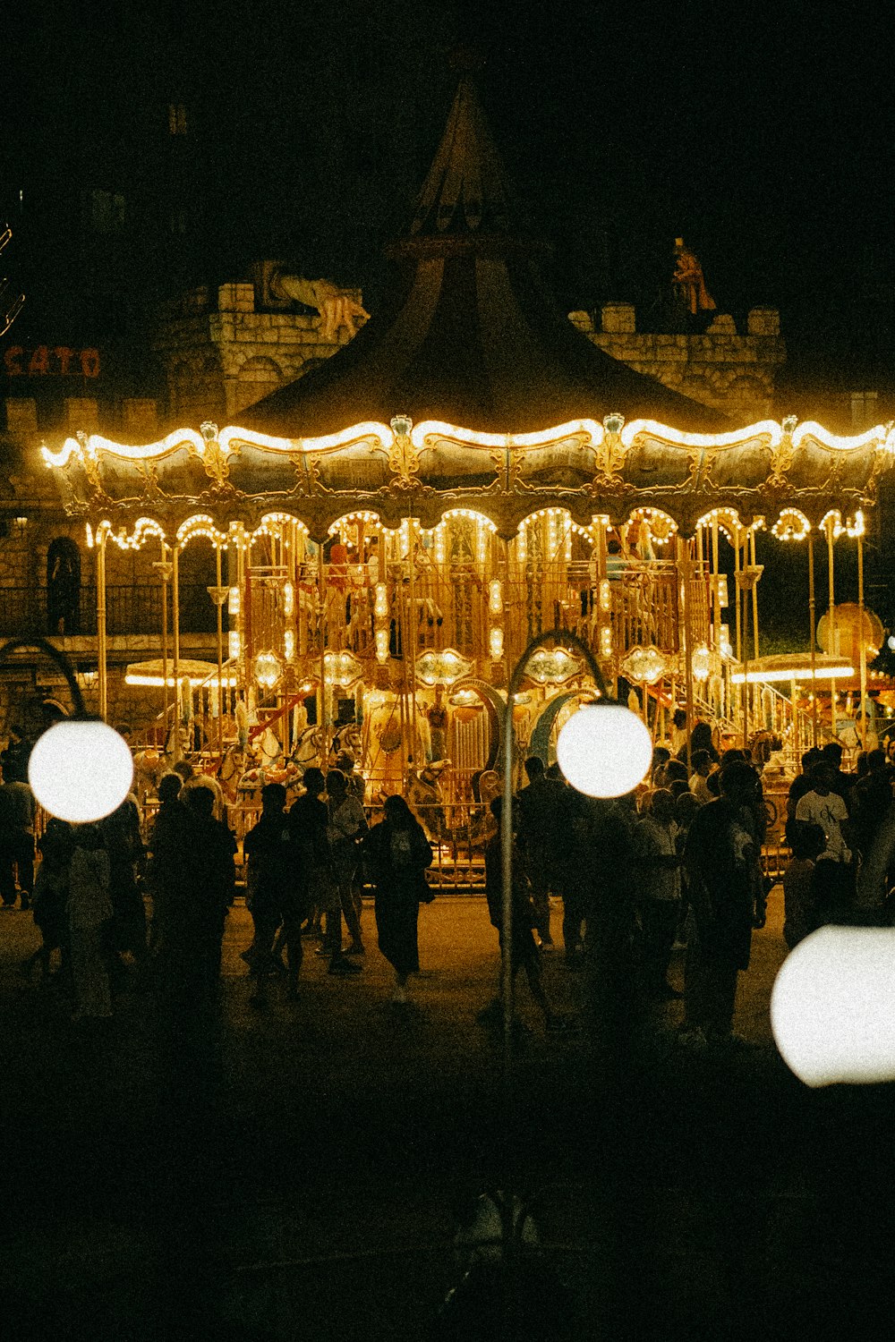 a group of people standing around a merry go round