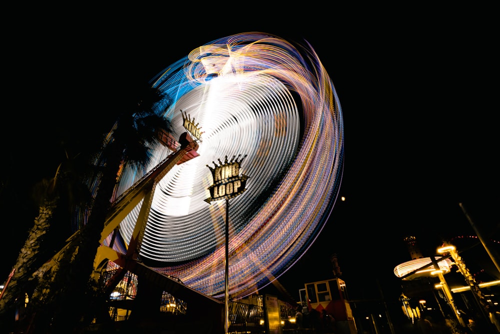 a ferris wheel spinning in the dark at night