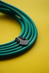 a close up of a green cable on a yellow surface