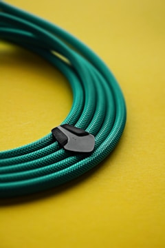 a close up of a green cable on a yellow surface