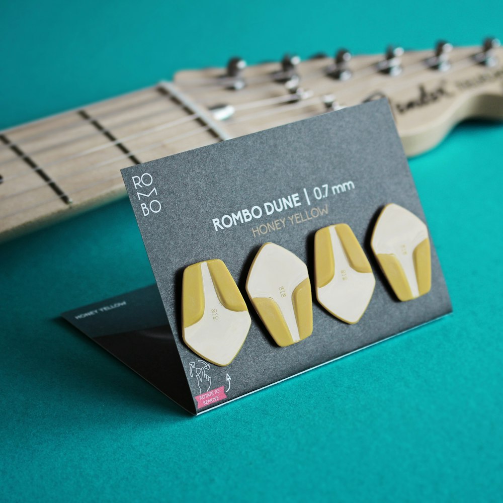 a pair of yellow and white earrings sitting on top of a guitar