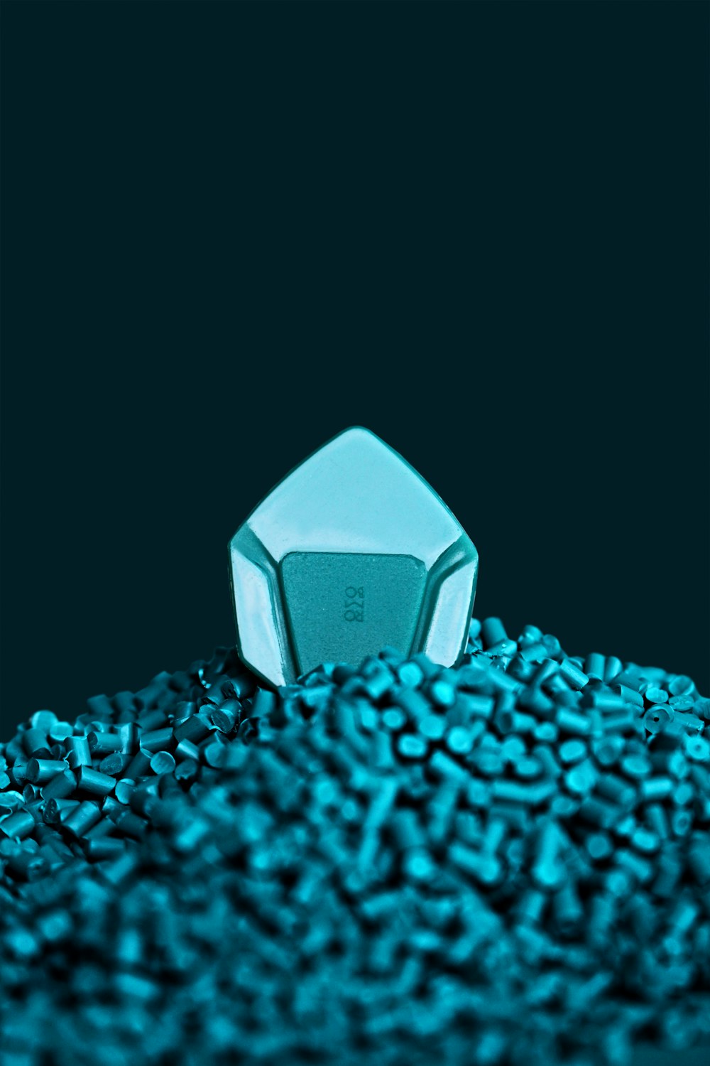 a blue object sitting on top of a pile of blue rocks