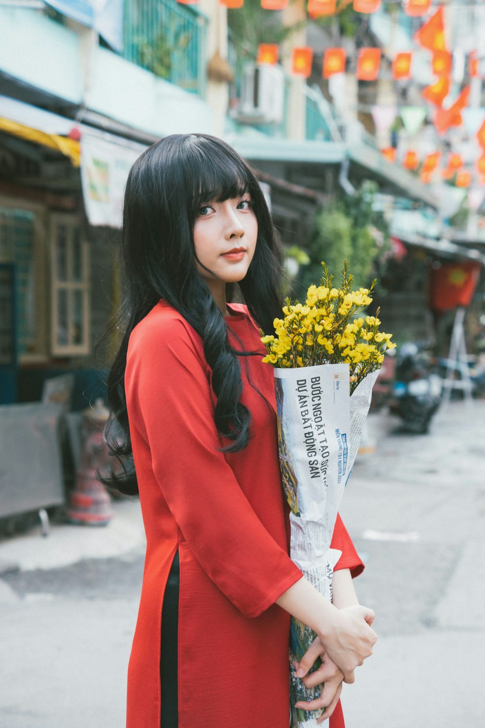 a woman in a red dress holding a bouquet of flowers