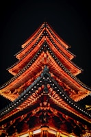 a tall building lit up at night with red lights