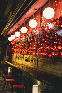A cozy outdoor seating area at dusk with soft glowing lanterns around.