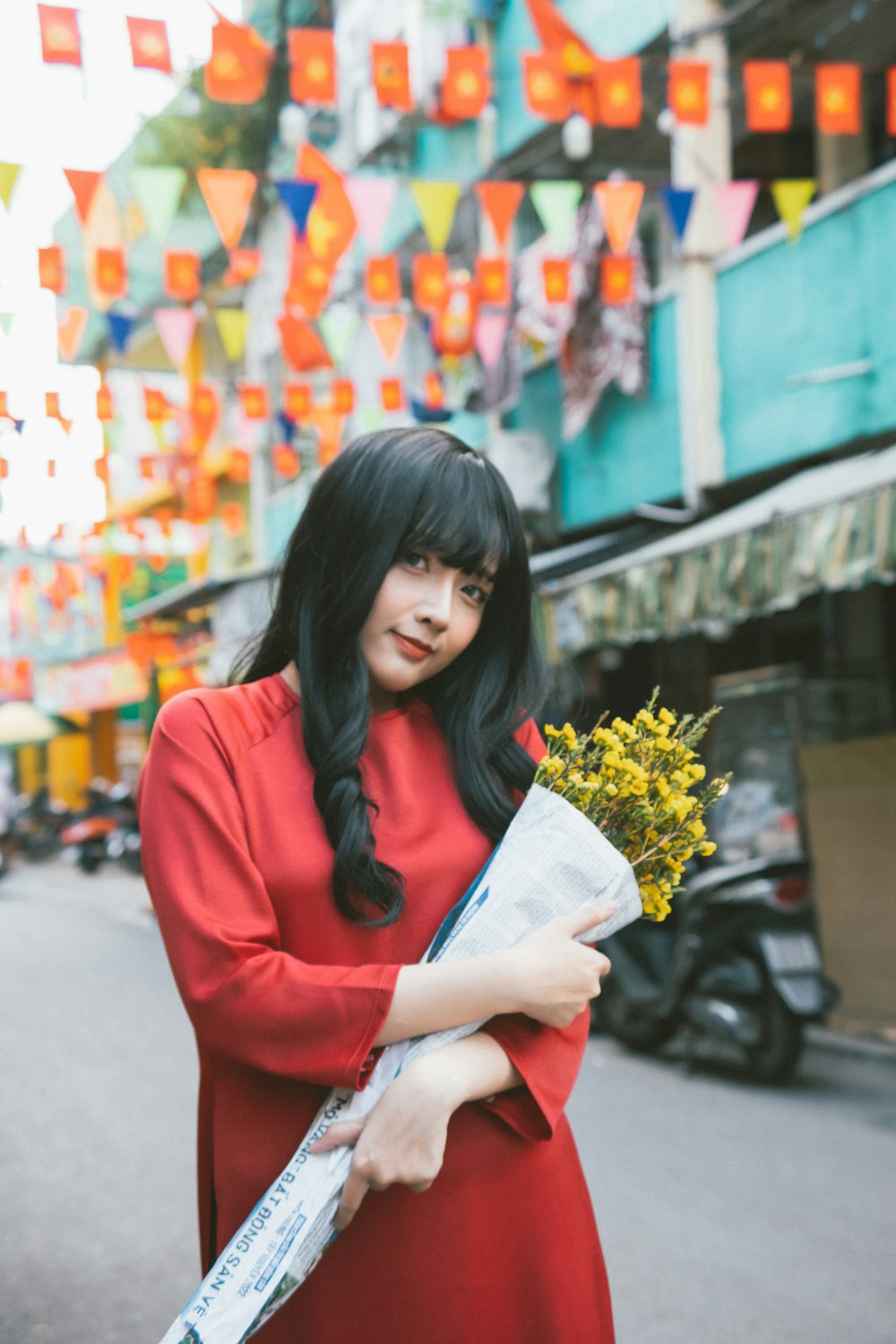a woman in a red dress holding a bouquet of flowers