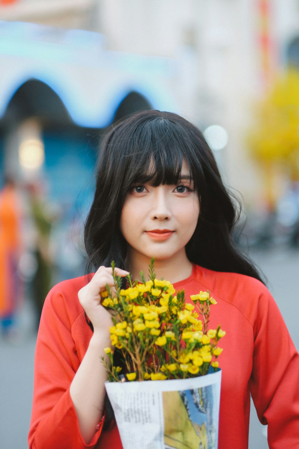 a woman holding a bouquet of yellow flowers