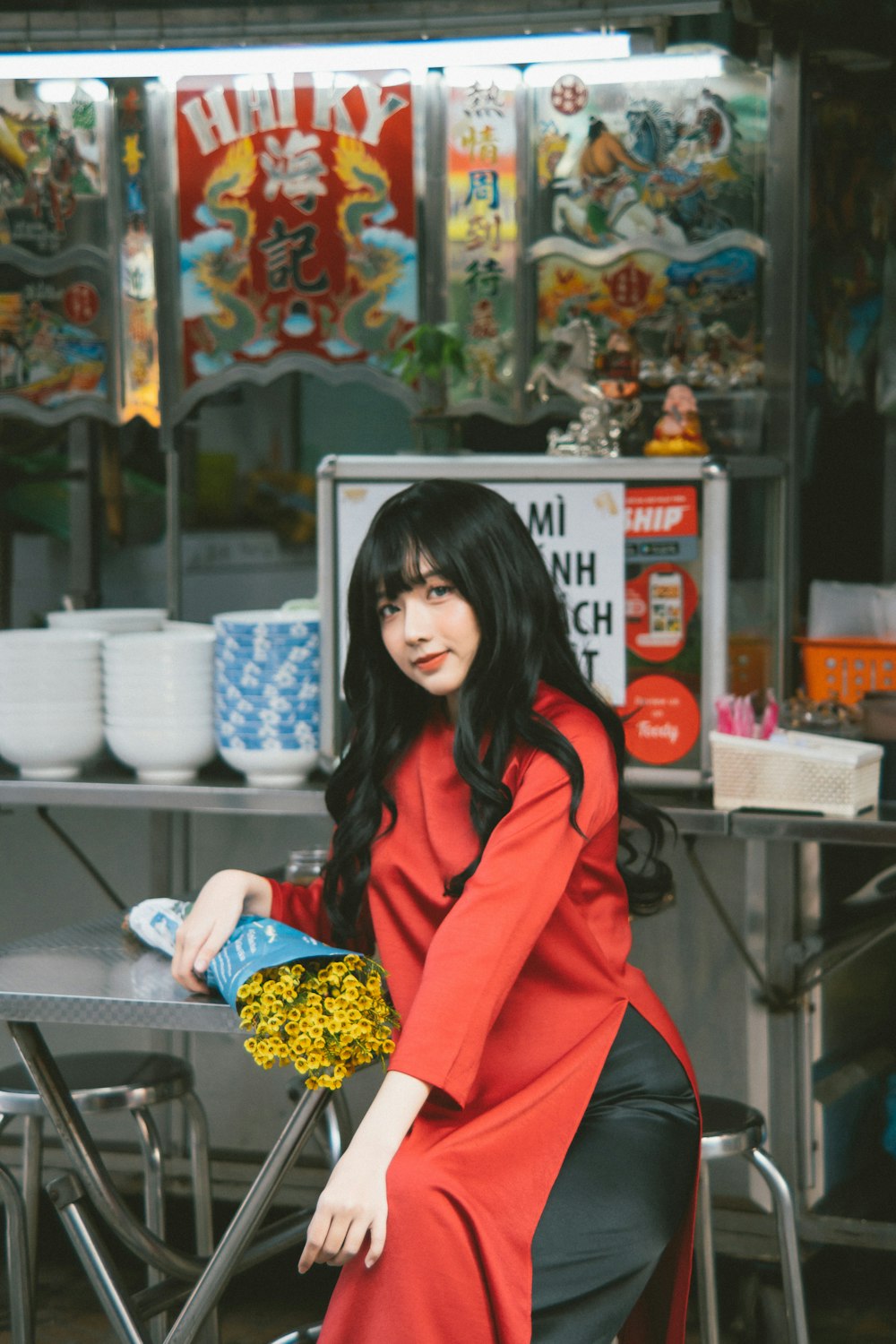 a woman in a red coat sitting at a table