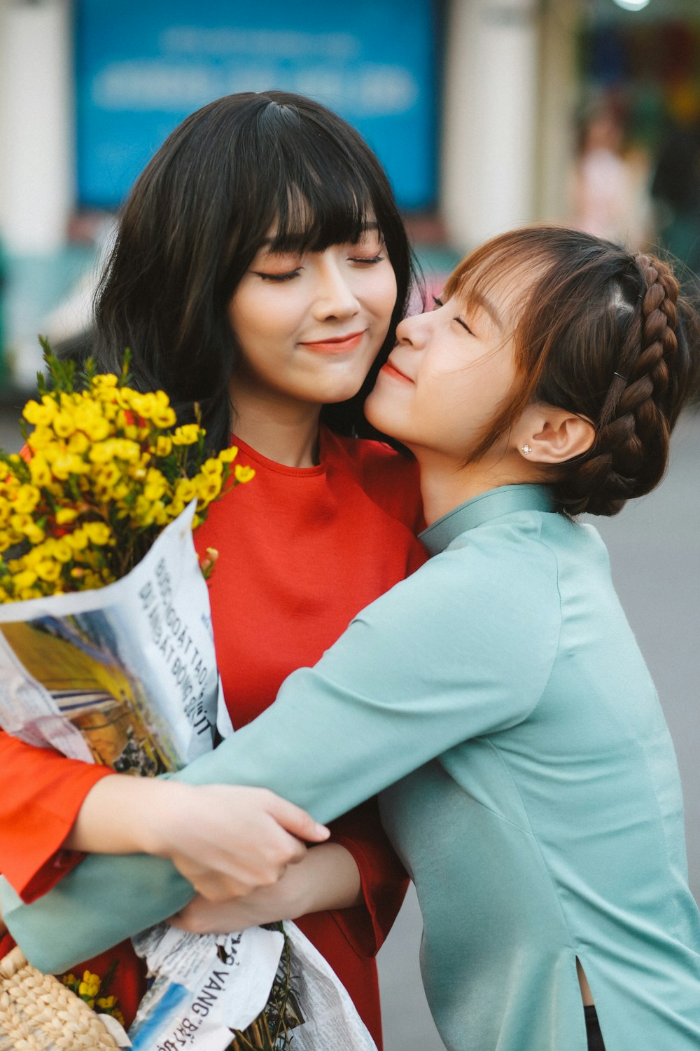 a woman kissing a statue of a woman holding a bouquet of flowers