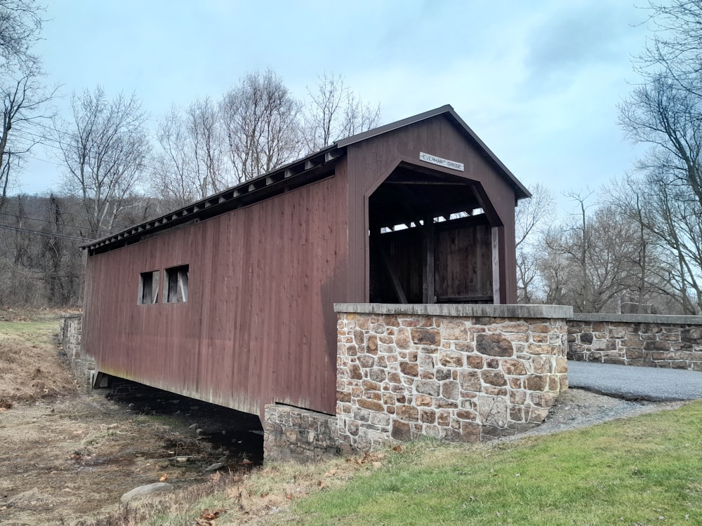 an old covered bridge with a stone wall