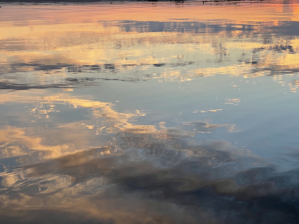 a large body of water with a sky in the background