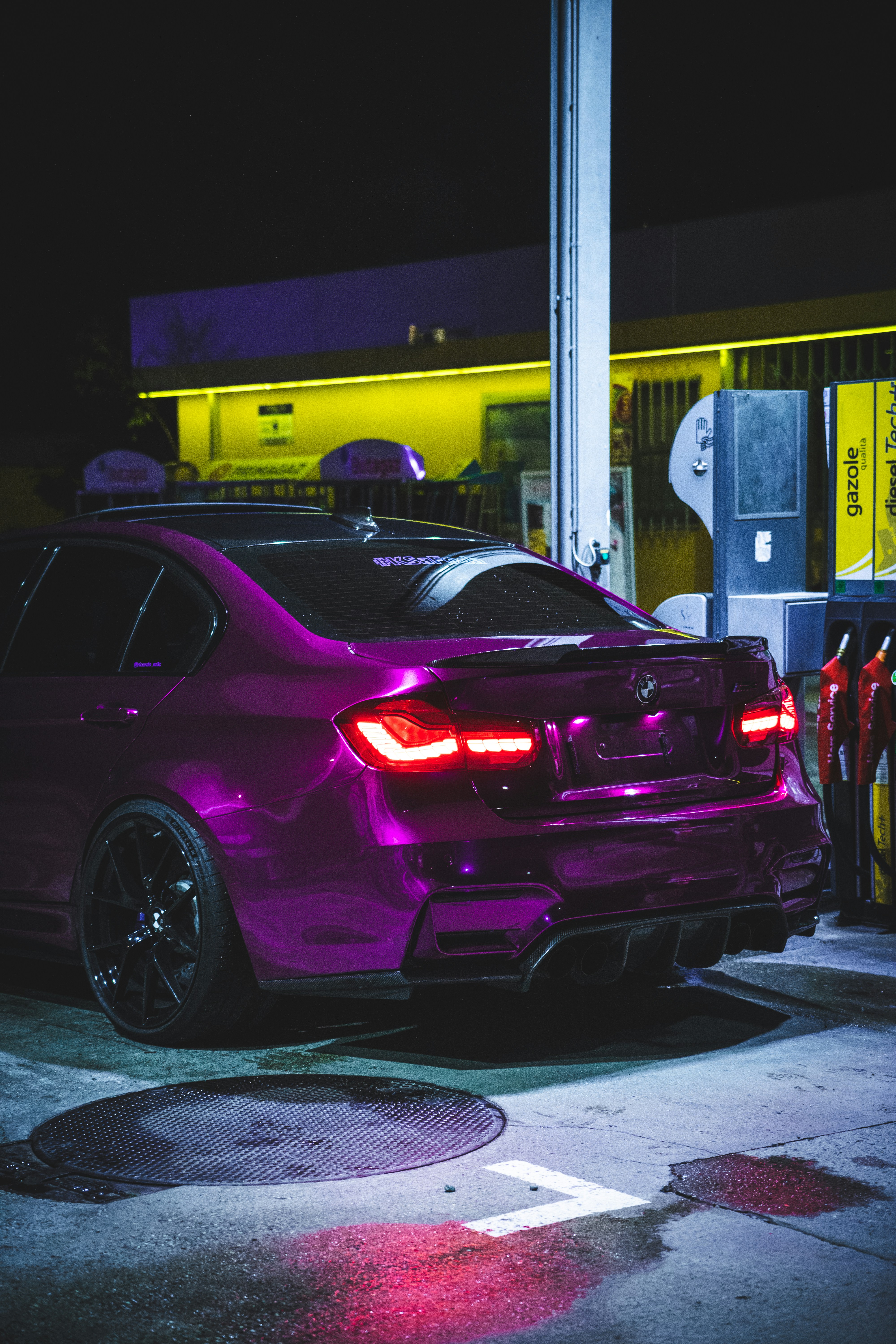 a purple car parked in front of a gas station