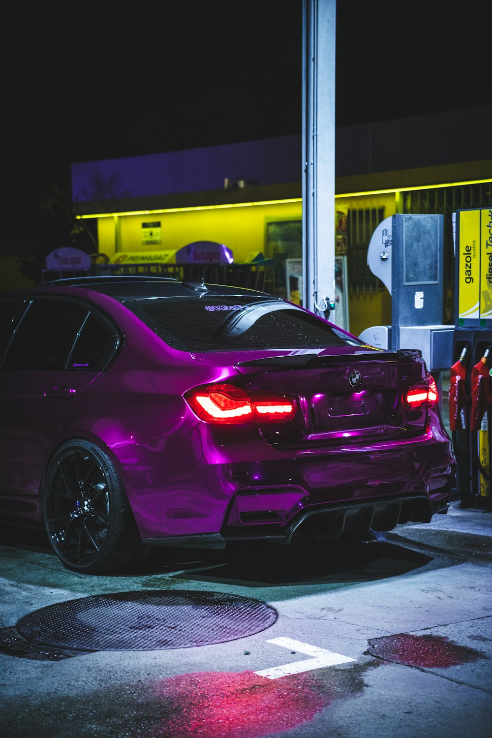 a purple car parked in front of a gas station