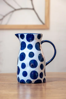 a blue and white vase sitting on top of a wooden table