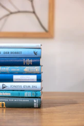 a stack of books sitting on top of a wooden table
