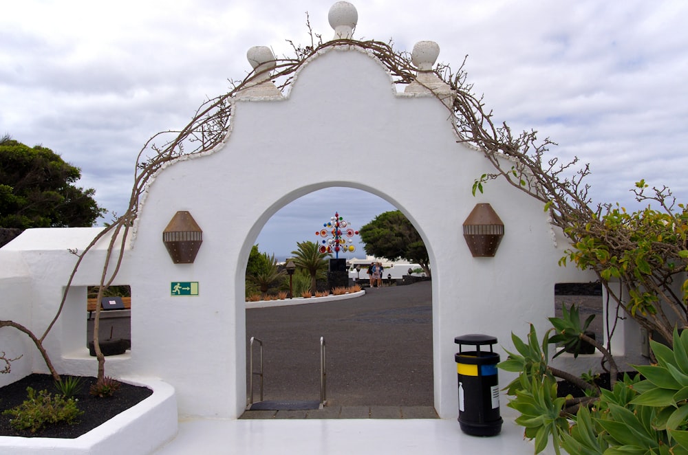 a white building with a gate and a street in the background