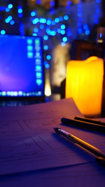 A calm workspace with a laptop and a softly glowing candle near a small potted plant.
