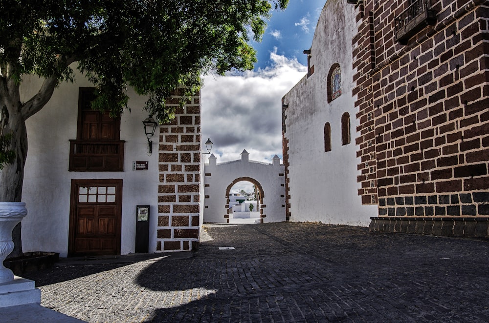 a brick walkway between two white buildings