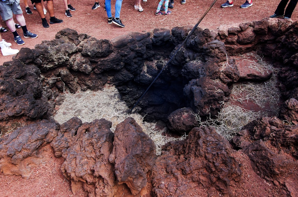 a group of people standing around a hole in the ground