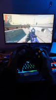 Close-up of a player’s hands on a keyboard, with vibrant game graphics on the screen.