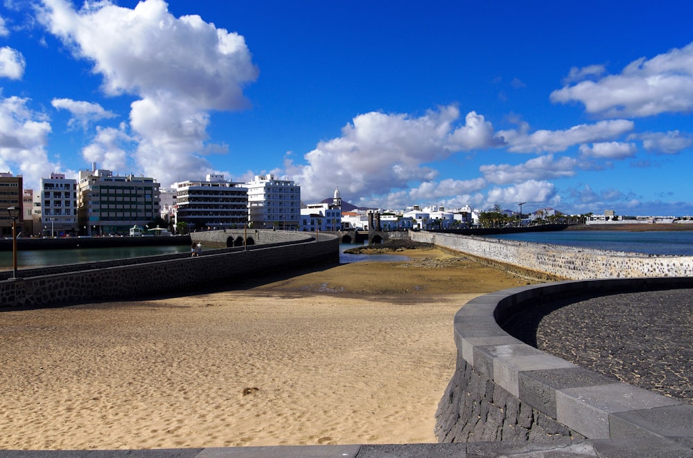 a sandy beach with buildings in the background