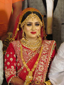 A bride in elegant traditional attire with flawless makeup and styled hair.