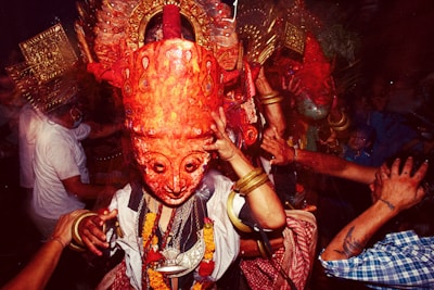 A lively ceremony with people dressed in red and black, dancing and celebrating.